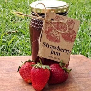 Jar of homemade strawberry jam bursting with fresh berry flavor, ideal for toast or pastries.