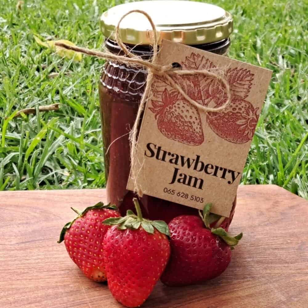 Jar of homemade strawberry jam bursting with fresh berry flavor, ideal for toast or pastries.