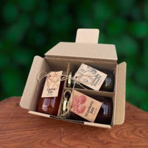 Curated gift box with fig preserve, strawberry jam, and apricot jam, tied with a festive ribbon.